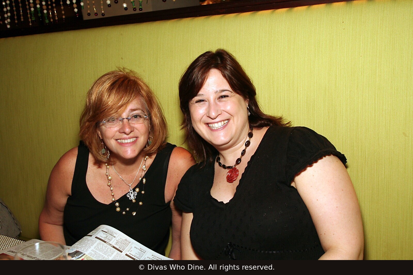 Two women seated together at a Divas Who Dine table in New York City in June 2006